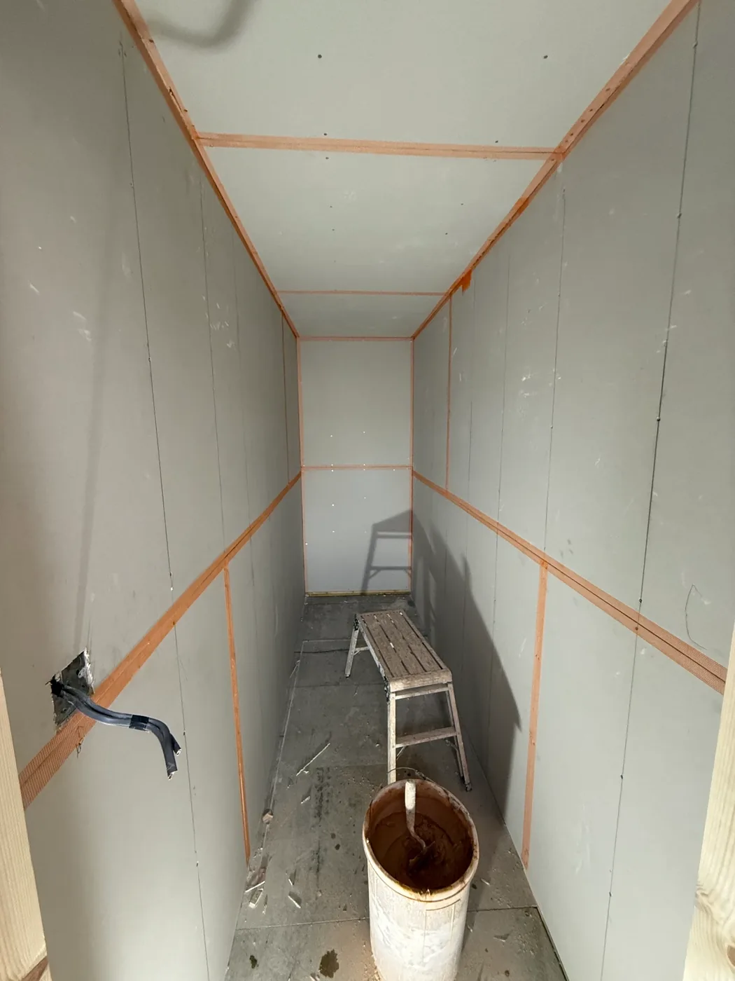 A corridor boarded out with the joints scrimmed, before skimming