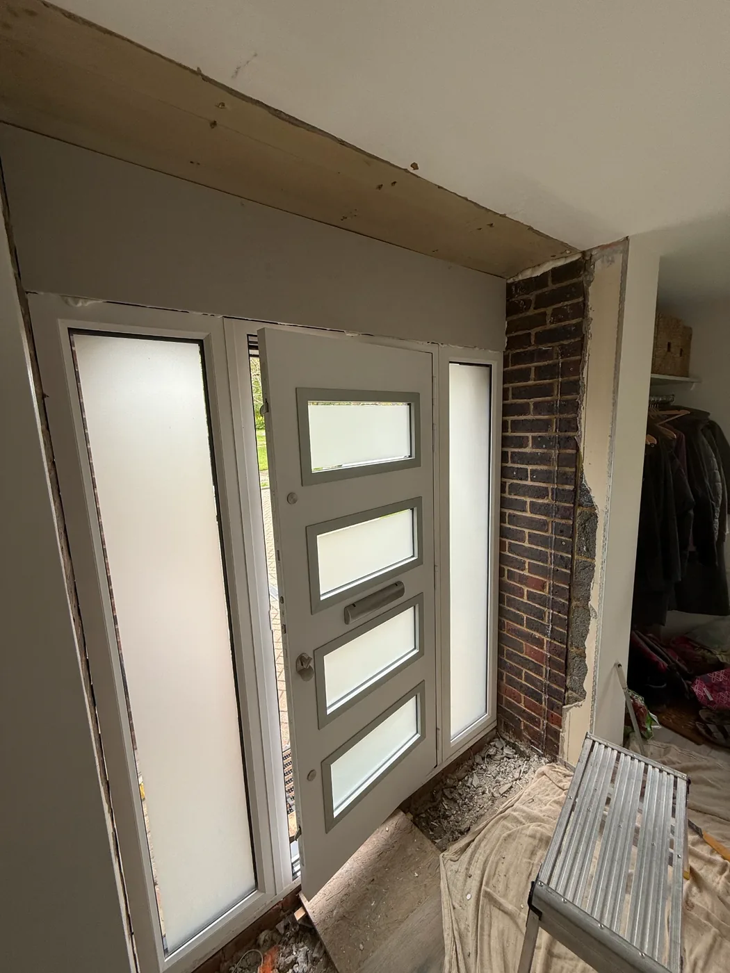 A front door surround with the brick pier exposed, before plastering