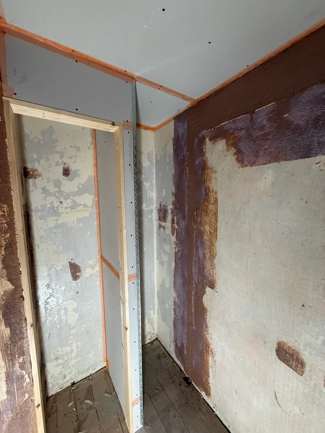 Blown plaster taken off back to the brick, with new board going up beside it
